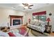 Cozy living room featuring a fireplace, ceiling fan, and large window for natural light at 2140 S Youngfield St, Lakewood, CO 80228