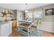 Eat-in kitchen boasts a farmhouse dining table, bench seating, decorative shelves, and updated cabinets at 5864 Turnstone Pl, Castle Rock, CO 80104