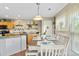 Bright dining area features a farmhouse table, pendant lighting, and large window with sheer curtains at 5864 Turnstone Pl, Castle Rock, CO 80104