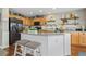 Well-lit kitchen with wood cabinets, a center island with stool seating, and modern appliances, offering style and functionality at 5864 Turnstone Pl, Castle Rock, CO 80104