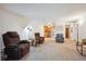 Open living space showing adjacent kitchen, neutral carpet, and comfortable seating at 710 S Clinton St # 1A, Denver, CO 80247