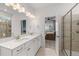 Bright bathroom features a double sink vanity with white cabinets and quartz countertops, plus a glass enclosed shower at 8132 Mt Harvard Rd, Littleton, CO 80125