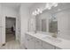 Bathroom featuring double sinks, a large mirror, and a view into the walk-in closet at 8132 Mt Harvard Rd, Littleton, CO 80125