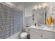 This bathroom features a shower with a patterned curtain, a toilet, and vanity with modern fixtures and a window at 8132 Mt Harvard Rd, Littleton, CO 80125