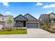 Charming blue two-story home featuring a stone accent, covered porch, attached garage, and landscaped yard at 8132 Mt Harvard Rd, Littleton, CO 80125