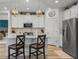 Well-lit kitchen showcases white cabinets, stainless steel refrigerator, and modern island seating at 8132 Mt Harvard Rd, Littleton, CO 80125