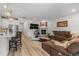 Open-concept living room with hardwood floors, a fireplace, access to the kitchen, and a comfortable sectional at 8132 Mt Harvard Rd, Littleton, CO 80125
