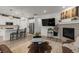 Open concept living room featuring a large TV, fireplace, hardwood floors, and access to the kitchen at 8132 Mt Harvard Rd, Littleton, CO 80125