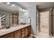 Bathroom features dual sinks, tile backsplash, a glass-enclosed shower and an open door to a walk-in closet at 237 Dayton St, Denver, CO 80230