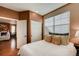 Bedroom featuring a cozy bed, neutral tones, hardwood floors, and view to the living room at 237 Dayton St, Denver, CO 80230