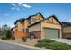 Charming two-story home featuring a well-manicured lawn, brick accents, and a modern garage door at 237 Dayton St, Denver, CO 80230