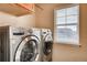 Laundry room boasts front load washer and dryer and natural light from window at 237 Dayton St, Denver, CO 80230
