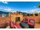 Inviting rooftop deck with a brick outdoor fireplace and comfortable seating beneath a bright sky at 237 Dayton St, Denver, CO 80230