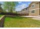 A spacious backyard with grass, a wooden fence, and a terraced garden at 2948 Open Sky Way, Castle Rock, CO 80109
