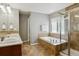 Bright bathroom with double sinks, a soaking tub, and a separate shower at 2948 Open Sky Way, Castle Rock, CO 80109