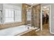 Well-lit bathroom features a tub, a glass-enclosed shower, and a walk in closet at 2948 Open Sky Way, Castle Rock, CO 80109