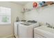 Well-lit laundry room includes a washer, dryer, utility sink, and storage shelf at 2948 Open Sky Way, Castle Rock, CO 80109