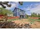 A large backyard featuring a red fence, stairs to the deck, a patio, and a fire pit at 21742 E Lehigh Pl, Aurora, CO 80018