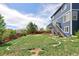 Discover this spacious backyard with a red fence, lush greenery, and deck access via stairs at 21742 E Lehigh Pl, Aurora, CO 80018