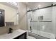 Modern bathroom with gray tile, a glass shower/tub combo, updated vanity and fixtures at 21742 E Lehigh Pl, Aurora, CO 80018