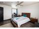 Bright bedroom with dark floors, ceiling fan, desk, and a window for natural light at 21742 E Lehigh Pl, Aurora, CO 80018