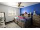 Bedroom featuring a large window, a blue accent wall, and a unique bed at 21742 E Lehigh Pl, Aurora, CO 80018