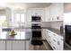 Bright kitchen featuring stainless steel appliances, granite countertops, white cabinetry, and gray laminate flooring at 21742 E Lehigh Pl, Aurora, CO 80018