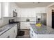 Bright kitchen featuring stainless steel appliances, granite countertops and white cabinetry, with a central island at 21742 E Lehigh Pl, Aurora, CO 80018