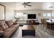 Open-concept living room featuring comfortable seating, ceiling fan, home gym, and laminate floors at 21742 E Lehigh Pl, Aurora, CO 80018