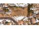 The aerial view shows the vacant lot and street, which is partially covered in snow at 434 S Newport Way, Denver, CO 80224