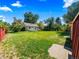 A serene, expansive back yard featuring lush green grass, mature trees, and a storage building at 1941 S Dexter St, Denver, CO 80222
