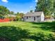 Backyard view showcasing green grass, a grey home exterior, blue sky, and mature trees at 1941 S Dexter St, Denver, CO 80222