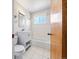 Bathroom view featuring a toilet, vanity sink, tiled shower/tub, a window, and modern lighting at 1941 S Dexter St, Denver, CO 80222