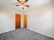 Bedroom view features neutral walls, gray carpeting, two wood-stained doors, and ceiling fan with lighting at 1941 S Dexter St, Denver, CO 80222