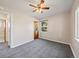 Bedroom view featuring neutral walls, gray carpet, wood door, and ceiling fan with lighting at 1941 S Dexter St, Denver, CO 80222