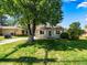 Inviting single-story home featuring a well-maintained front lawn, mature tree and a cozy front porch at 1941 S Dexter St, Denver, CO 80222