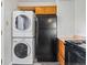 Stacked laundry machines next to black refrigerator at 1941 S Dexter St, Denver, CO 80222