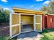 Red storage shed with open doors reveals a spacious interior, ready for tools and projects at 1941 S Dexter St, Denver, CO 80222