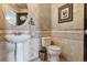 Elegant powder room with a round mirror, pedestal sink, and stylish tile work at 1563 Baguette Dr, Castle Rock, CO 80108