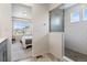 Bathroom with white subway tile shower and view into a bright bedroom with neighborhood views at 4408 Riviera Ct, Aurora, CO 80019