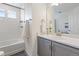 Bathroom features tub, white tiled walls, grey cabinets, and stylish decor at 4408 Riviera Ct, Aurora, CO 80019