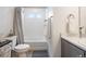 Bathroom features tub, shower, white tiled walls, and grey cabinets at 4408 Riviera Ct, Aurora, CO 80019