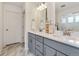 Bathroom with double sinks, gray cabinets, granite counters, and a tiled walk-in shower at 4408 Riviera Ct, Aurora, CO 80019