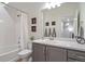 Bathroom features a tub with shower, grey cabinets, white countertop, and stylish decor at 4408 Riviera Ct, Aurora, CO 80019