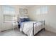 Bright bedroom with carpeted floor, large window and a black metal frame bed with blue accents at 4408 Riviera Ct, Aurora, CO 80019