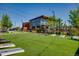 An outdoor community space with a large lawn, cornhole, and dining areas at 4408 Riviera Ct, Aurora, CO 80019