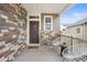 Charming front porch with brick accents and cozy seating area at 4408 Riviera Ct, Aurora, CO 80019