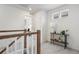 Bright hallway features neutral tones, wood railing, console table, and view into bedroom at 4408 Riviera Ct, Aurora, CO 80019