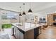 Spacious kitchen with island, bar seating, and modern appliances open to the living area at 4408 Riviera Ct, Aurora, CO 80019
