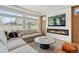 Bright living room featuring a fireplace, large windows and a comfortable sectional sofa at 4408 Riviera Ct, Aurora, CO 80019